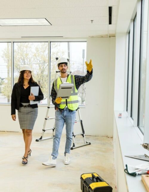 The male foreman supervisor walks in the new building with the female city employee to confirm the timeline for their permit requests.